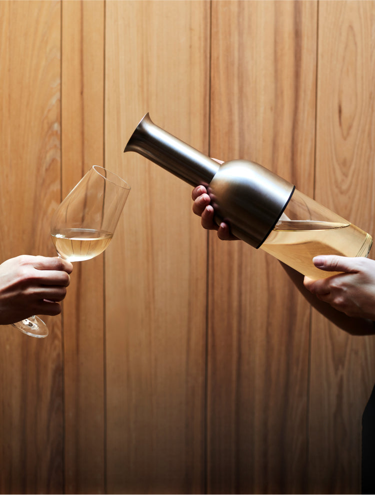 A man pours white wine from the ETO decanter into an outreached glass