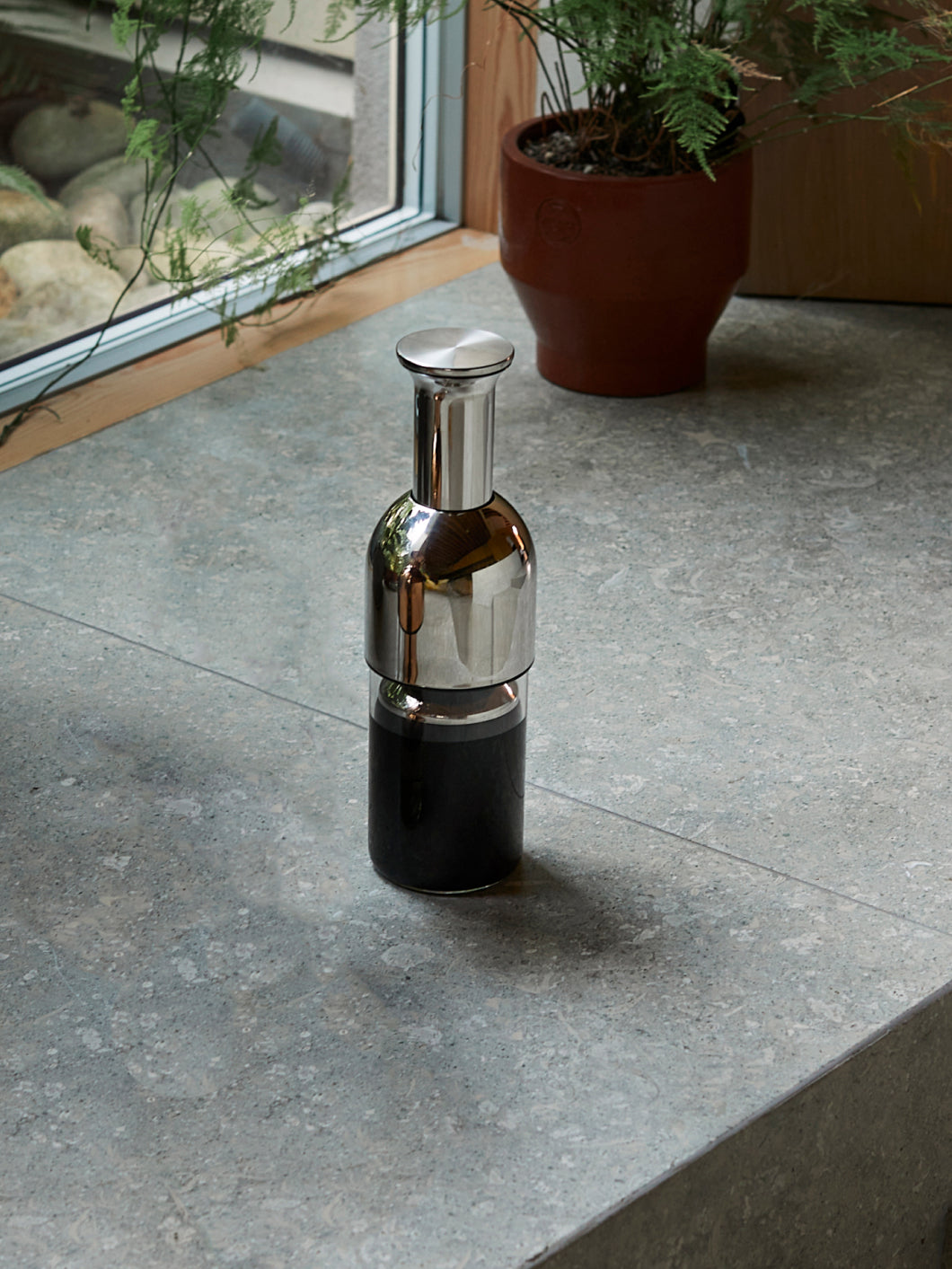 stainless mirror eto wine decanter on a polished concrete surface