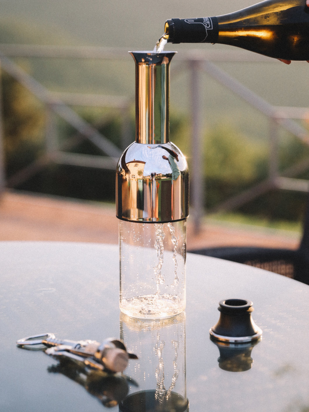 A bottle of white wine being poured into the eto wine decanter