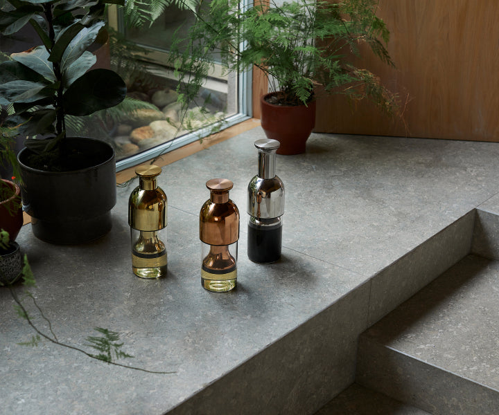 Three mirror finish eto wine decanters in gold, copper and stainless steel.