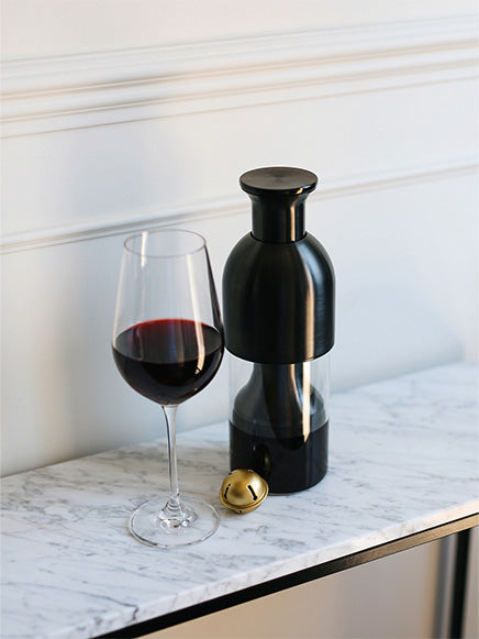 Graphite steel eto wine decanter filled with red wine on top of a marble shelf