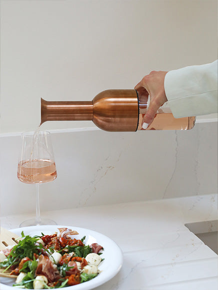 pouring a glass of rose from an eto wine decanter in copper satin finish